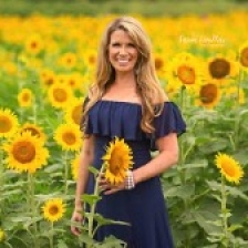 Woman standing in field of sunflowers