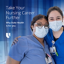 Two Nurses in Blue Scrubs Hug 