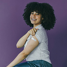 Woman with sleeve rolled up showing bandage from vaccination IG