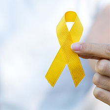 Suicide awareness yellow ribbon held by a person
