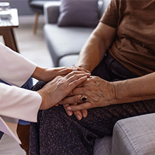 Caregiver holds patient hand for IG