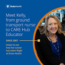 Kelly smiling at computer in Duke blue.
