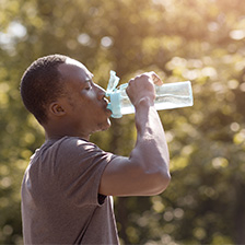 Man drinks from bottle while exercising