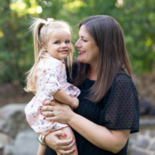 mother holding daughter and smiling