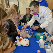 doctor putting breathing machine on a teddy bear