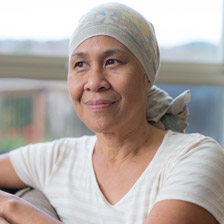 woman with a headscarf on looks out the window 