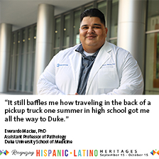 Everardo Macias in front of a building with graphics highlighting Hispanic-Latino Heritages month