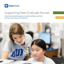 Two nurses working together on a computer. 