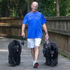 Man walking dog near fence