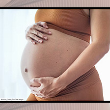 Woman holds pregnant belly