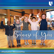 A group of children stand with their arms raised in celebration -- there are five kids, a mix of boys and girls and multiple races. 