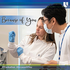Researchers look at sample in a lab setting with Because of You message and #thankathon hashtag