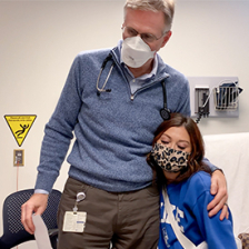 Dr. John Reynolds hugs Taylor Stephenson in a patient room