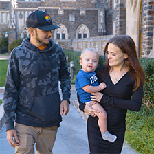 Brianna Ellington smiles at her son , Landon, while she holds him and walks with her partner