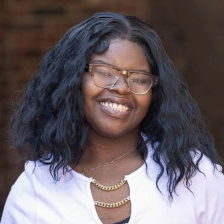 J'Asia stands outside smiling at the camera