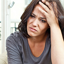 woman in pain with her hand on her head