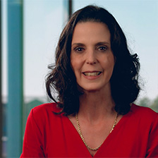 Nicole Clagett in a TV studio wearing a red outfit