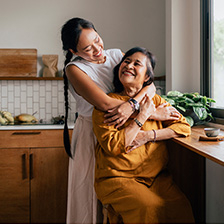 Women embrace in kitchen