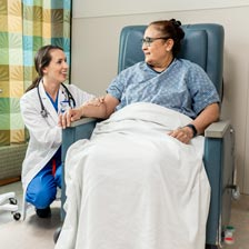 A doctor sits next to a patient