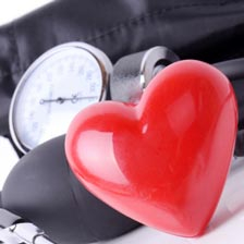 a heart charm sits next to a blood pressure cuff