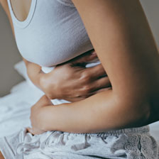 woman clutches her stomach