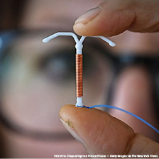 Researcher holds IUD in her hands