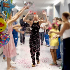 Isabella walks through a crowd of people celebrating her recovery with confetti