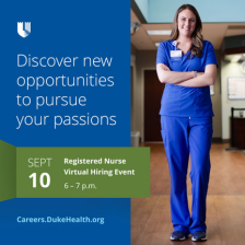 Nursing team member smiles in blue scrubs with arms crossed. 