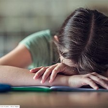 Child with head on table on classroom setting