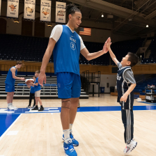A Duke Men's basketball player high fives a Duke Children's patient
