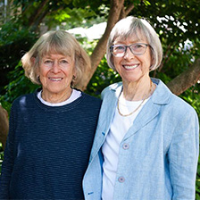 Sisters Rebecca Kirkland and Mary Trent Jones in front of a floral setting