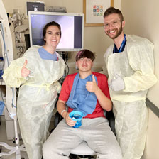 Richard gives a thumbs up with his doctors after procedure