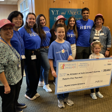 A bunch of people standing with a check 