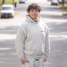 Fernando Morazán stands on his street and smiles