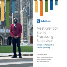 Glendon smiles in a suit in front of the Duke chapel. 