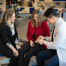 Neill Y. Li and Theresa Hallene inspect Jessi's hand