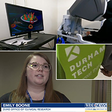 A student uses a robotic computer, a backpack with Durham Tech on it and a portrait of Emily Boone, Duke Office of Clinical Research