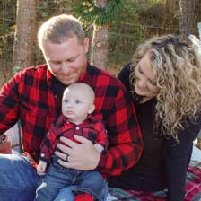 Tyler Wilfong shares a loving moment with his wife and baby boy.