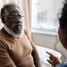 A man sits in the doctor's office and listens to the doctor