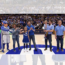 Blue Devil mascot stands with UNC Health and Duke Health representatives and patients at center court of a basketball game