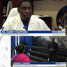 Dr Harry Stafford and Robert Turner talk to reporters in an office and clinic setting.