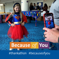 A little girl in a Halloween costume smiles for a phone camera