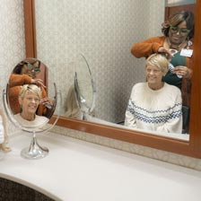 Deb smiles in the mirror as she gets her hair done