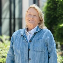 Deborah stands outside and smiles