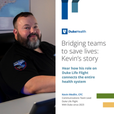 Kevin smiles in a black Duke Life Flight polo in the communications center.