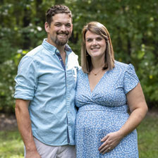 Kyle and a pregnant Chelsae stand together outside