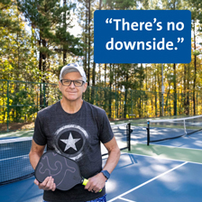 Jeff Peeler smiles at the camera on a pickleball court with a racket