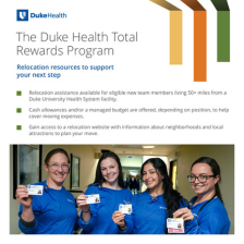 Four healthcare professionals in blue uniforms smiling and holding their employee ID badges at Duke Health.