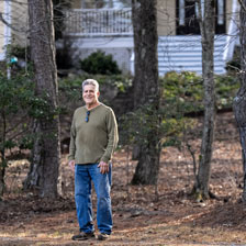 Mickey Whyte stands outside his home in front of trees