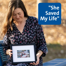 Kathryn sits in the park and looks down at a picture of her mother